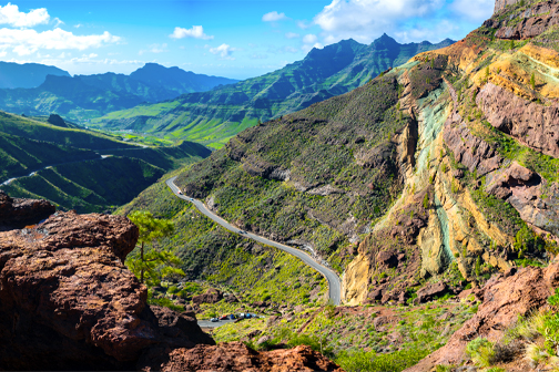 Rainbow Rocks op Gran Canaria met kleurrijk beschilderde rotsen langs een bergweg, omringd door het droge vulkanische landschap.